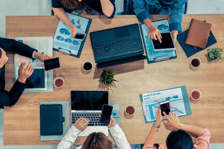 Top view of businessman executive in group meeting with other businessmen and businesswomen in modern office with laptop computer, coffee and document on table. People corporate business team concept.の写真素材