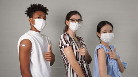 Diverse group of people showing COVID-19 vaccine bandage merrily in concept of coronavirus vaccination program to vaccinate citizen .の写真素材