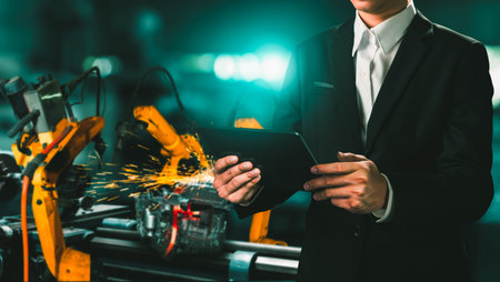 Engineer use advanced robotic software to control industry robot arm in factory . Automation...