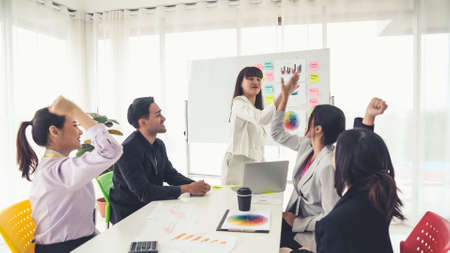 Business people proficiently celebrate project success at office workplace . Corporate business team collaboration concept .の写真素材