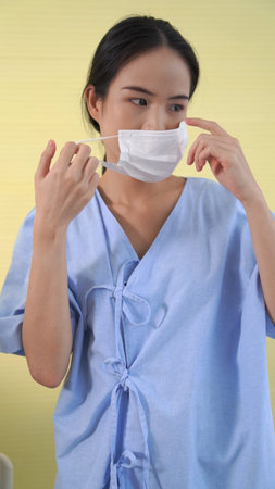 Young Asian woman take off face mask removing from face showing concept of the end of quarantineの写真素材