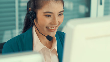 Businesswoman wearing headset working actively in office . Call center, telemarketing, customer...