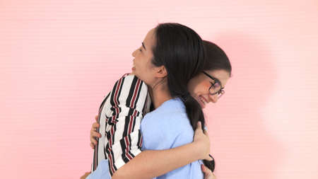 Happy friends take off face mask and hug each other closely together showing concept of the end of quarantine and winning.の写真素材