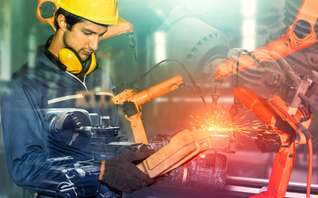 Mechanized industry robot arm and factory worker double exposure . Concept of robotics technology...