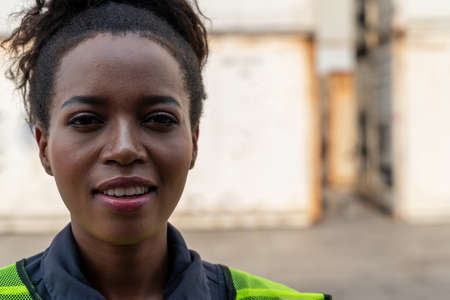 Young African American woman worker at overseas shipping container yard . Logistics supply chain management and international goods export concept .の写真素材