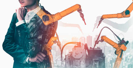Mechanized industry robot arm and factory worker double exposure . Concept of robotics technology for industrial revolution and automated manufacturing process .の写真素材