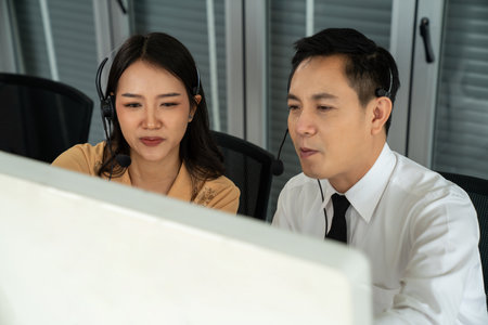 Business people wearing headset working actively in office . Call center, telemarketing, customer support agent provide service on telephone video conference call.の写真素材