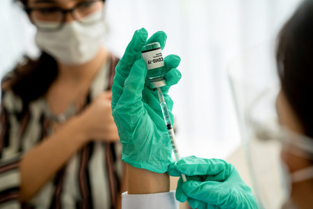 Young woman visits skillful doctor at hospital for vaccination . Covid 19 and coronavirus...