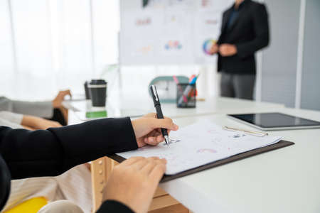 Businesswoman in business meeting writing paper proficiently at office room . Corporate business team collaborationの写真素材