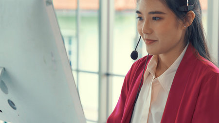 Businesswoman wearing headset working actively in office . Call center, telemarketing, customer...