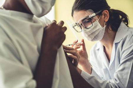 Young man visits skillful doctor at hospital for vaccination . Covid 19 and coronavirus vaccination...