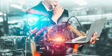 Mechanized industry robot arm and factory worker double exposure . Concept of robotics technology for industrial revolution and automated manufacturing process .の写真素材