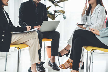 Business people proficiently discuss work project while sitting in circle . Corporate business team collaboration concept .の写真素材