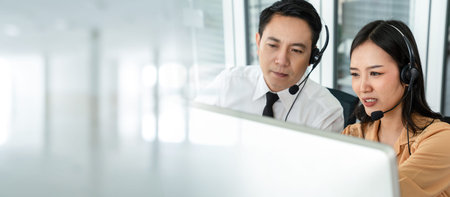 Business team wearing headset working actively in office . Call center, telemarketing, customer support agent provide service on telephone video conference call.の写真素材