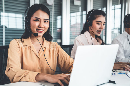 Business people wearing headset working actively in office . Call center, telemarketing, customer...