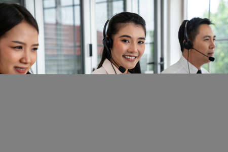 Business people wearing headset working actively in office . Call center, telemarketing, customer support agent provide service on telephone video conference call.の写真素材