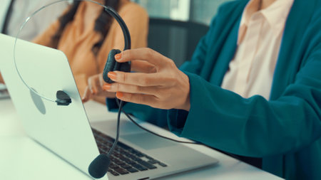 Businesswoman wearing headset working actively in office . Call center, telemarketing, customer support agent provide service on telephone video conference call.の写真素材