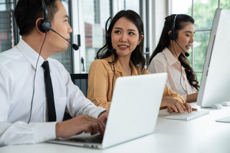 Business people wearing headset working actively in office . Call center, telemarketing, customer support agent provide service on telephone video conference call.の写真素材