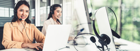 Business team wearing headset working actively in office . Call center, telemarketing, customer...