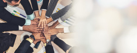 Happy business people celebrate teamwork success together with joy at office table shot from top...