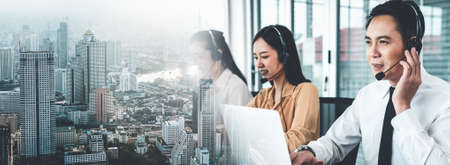 Business team wearing headset working actively in office . Call center, telemarketing, customer support agent provide service on telephone video conference call.の写真素材