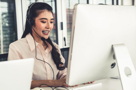 Businesswoman wearing headset working actively in office . Call center, telemarketing, customer...