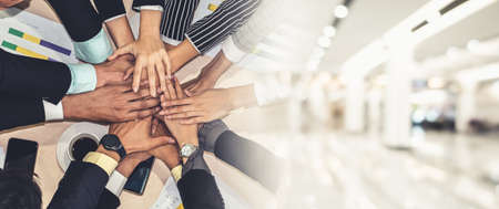 Happy business people celebrate teamwork success together with joy at office table shot from top view . Young businessman and businesswoman workers express cheerful victory in broaden view .の写真素材