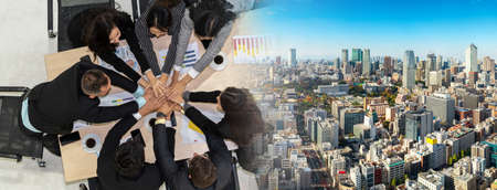 Happy business people celebrate teamwork success together with joy at office table shot from top view . Young businessman and businesswoman workers express cheerful victory in broaden view .の写真素材