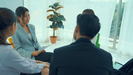 Business people proficiently discuss work project while sitting in circle . Corporate business team collaboration concept .の写真素材