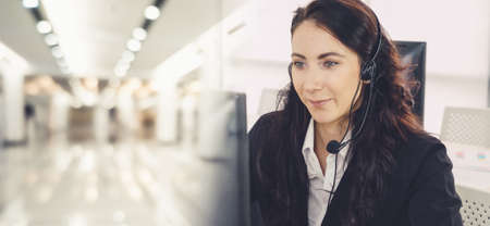Business people wearing headset working in office to support remote customer or colleague. Call center, telemarketing, customer support agent provide service in broaden view .の写真素材