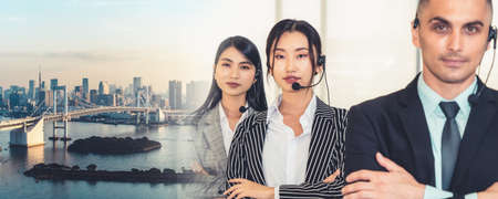 Business people wearing headset working in office to support remote customer or colleague. Call center, telemarketing, customer support agent provide service in broaden view .の写真素材