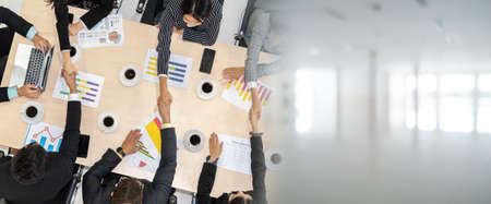 Group business people handshake at meeting table in office together with confident shot from top view . Young businessman and businesswoman workers express agreement of investment deal. broaden viewの写真素材