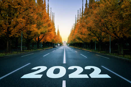 2022 New Year road trip travel and future vision concept . Nature landscape with highway road leading forward to happy new year celebration in the beginning of 2022 for fresh and successful start .の写真素材