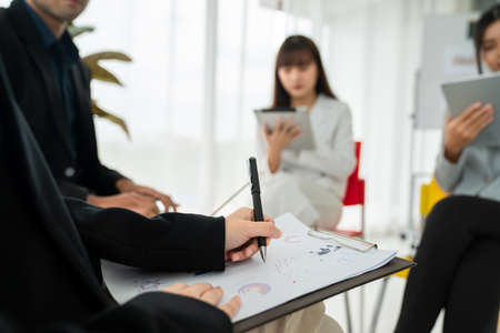 Business people proficiently discuss work project while sitting in circle . Corporate business team collaboration concept .の写真素材