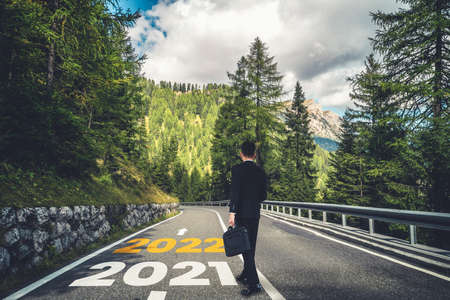 The 2022 New Year journey and future vision concept . Businessman traveling on highway road leading forward to happy new year celebration in beginning of 2021 for fresh and successful start .の写真素材