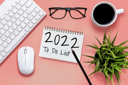 2022 Happy New Year Resolution Goal List and Plans Setting - Business office desk with notebook written about plan listing of new year goals and resolutions setting. Change and determination concept.の写真素材