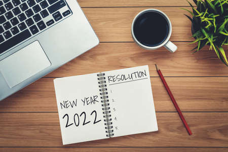 2022 Happy New Year Resolution Goal List and Plans Setting - Business office desk with notebook written about plan listing of new year goals and resolutions setting. Change and determination concept.の写真素材