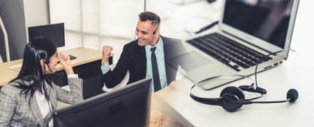 Business people wearing headset celebrate working in office . Call center, telemarketing, customer...