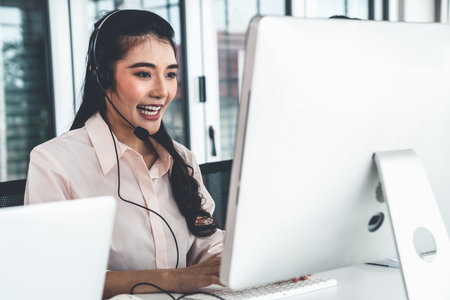 Businesswoman wearing headset working actively in office . Call center, telemarketing, customer...