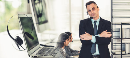 Business people wearing headset working in office to support remote customer or colleague. Call center, telemarketing, customer support agent provide service in broaden view .の写真素材