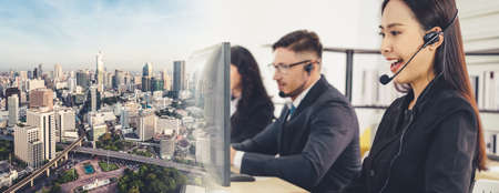 Business people wearing headset working in office to support remote customer or colleague. Call center, telemarketing, customer support agent provide service in broaden view .の写真素材