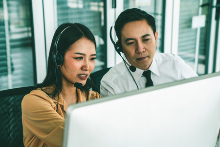 Business people wearing headset working actively in office . Call center, telemarketing, customer support agent provide service on telephone video conference call.の写真素材