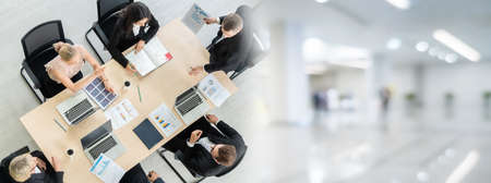Business people group meeting shot from top widen view in office . Profession businesswomen, businessmen and office workers working in team conference with project planning document on meeting table .の写真素材