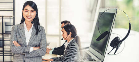 Business people wearing headset working in office to support remote customer or colleague. Call center, telemarketing, customer support agent provide service in broaden view .の写真素材