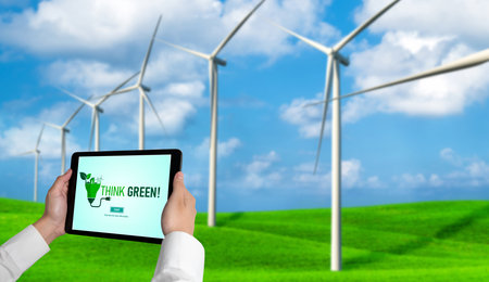 Green business transformation for environment saving and ESG business concept. Businessman using tablet to set corporate goal toward environmental friendly management and alternative clean energy use.の写真素材