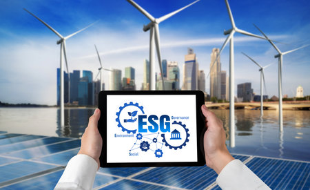 Green business transformation for environment saving and ESG business concept. Businessman using tablet to set corporate goal toward environmental friendly management and alternative clean energy use.の写真素材