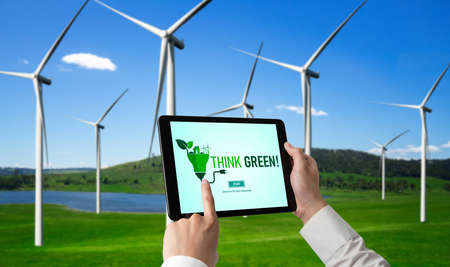 Green business transformation for environment saving and ESG business concept. Businessman using tablet to set corporate goal toward environmental friendly management and alternative clean energy use.の写真素材