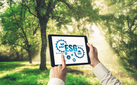 Green business transformation for environment saving and ESG business concept. Businessman using tablet to set corporate goal toward environmental friendly management and alternative clean energy use.の写真素材