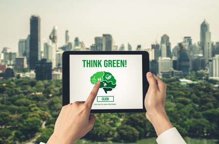 Green business transformation for environment saving and ESG business concept. Businessman using tablet to set corporate goal toward environmental friendly management and alternative clean energy use.の写真素材