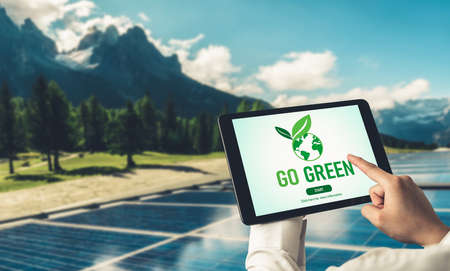 Green business transformation for environment saving and ESG business concept. Businessman using tablet to set corporate goal toward environmental friendly management and alternative clean energy use.の写真素材